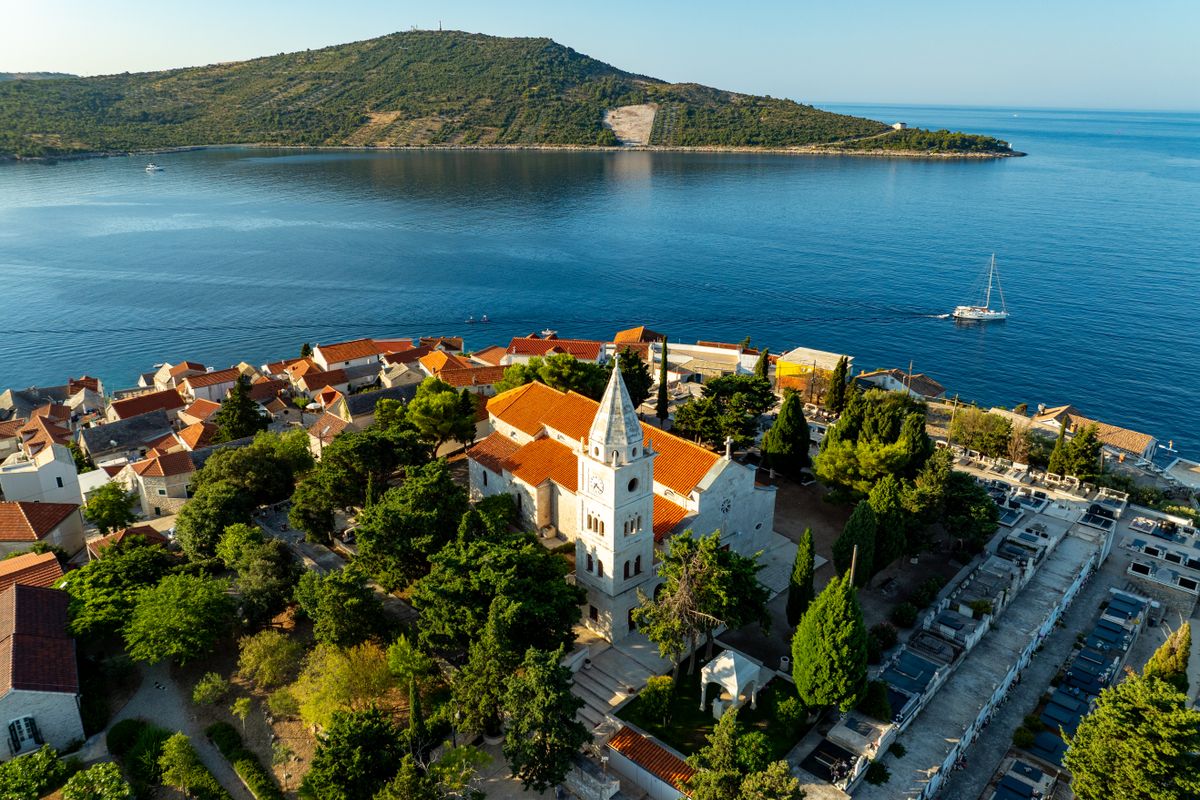A beautiful traditional gulet charter Croatia sailing near the island of Hvar at sunset, capturing the essence of lux…